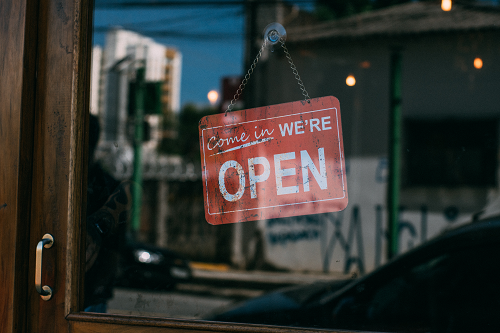 An "open" sign in a store front window.