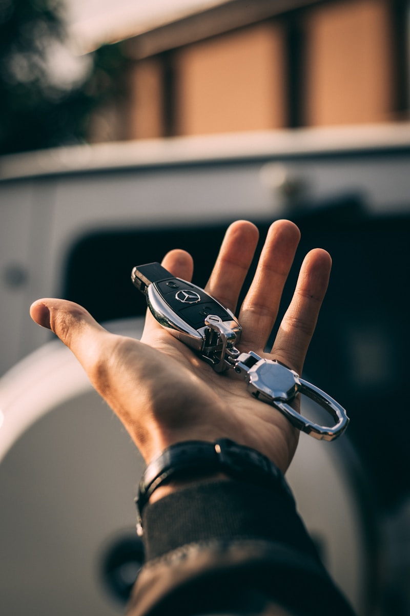 person holding Mercedes-Benz fob with vehicle title