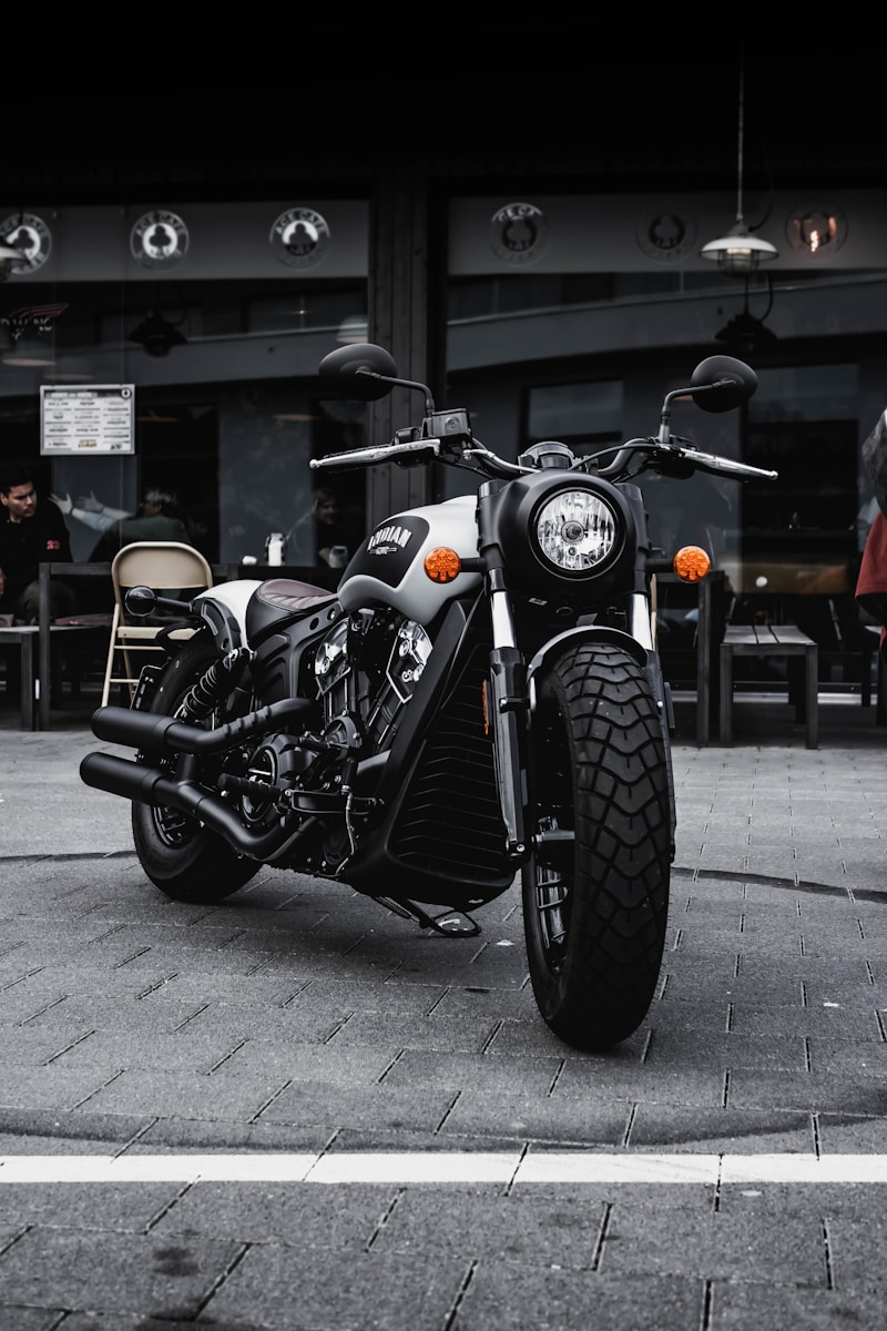 black and gray cruiser motorcycle parked beside black concrete building with motorcycle insurance